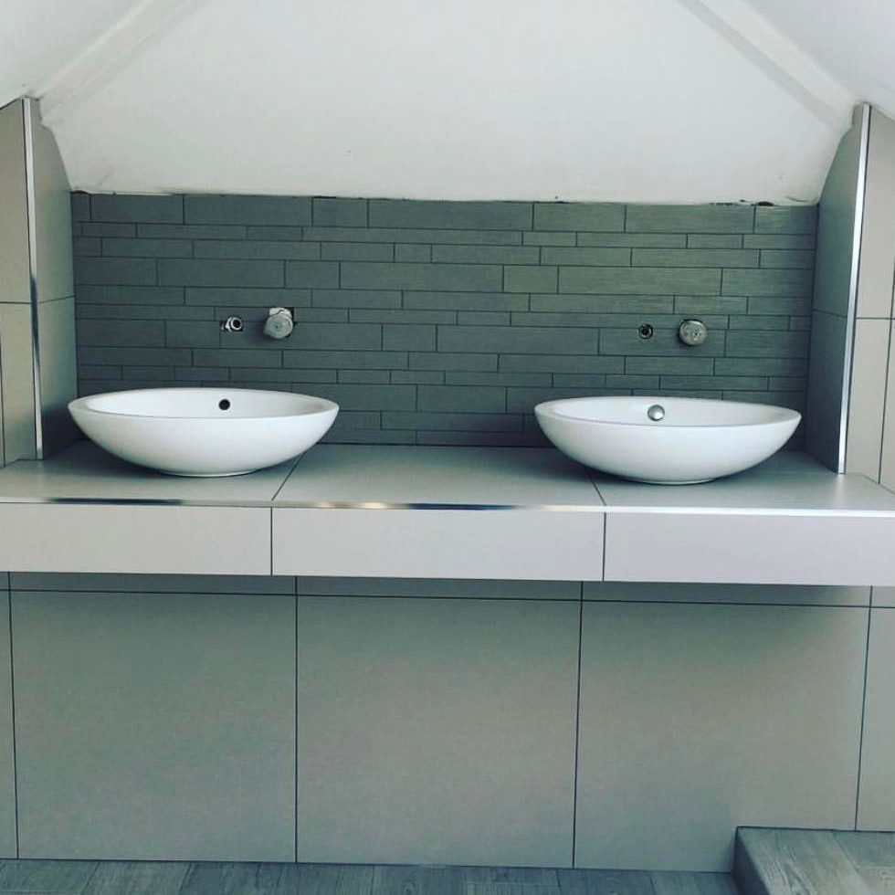 Bathroom with double sinks and textured backsplash