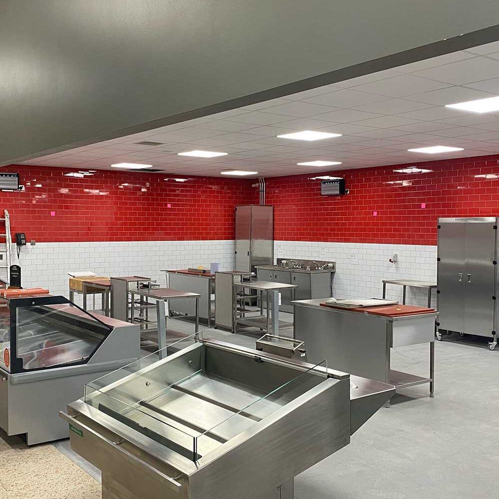 Commercial Kitchen in a supermarket with half red and half white tiled walls