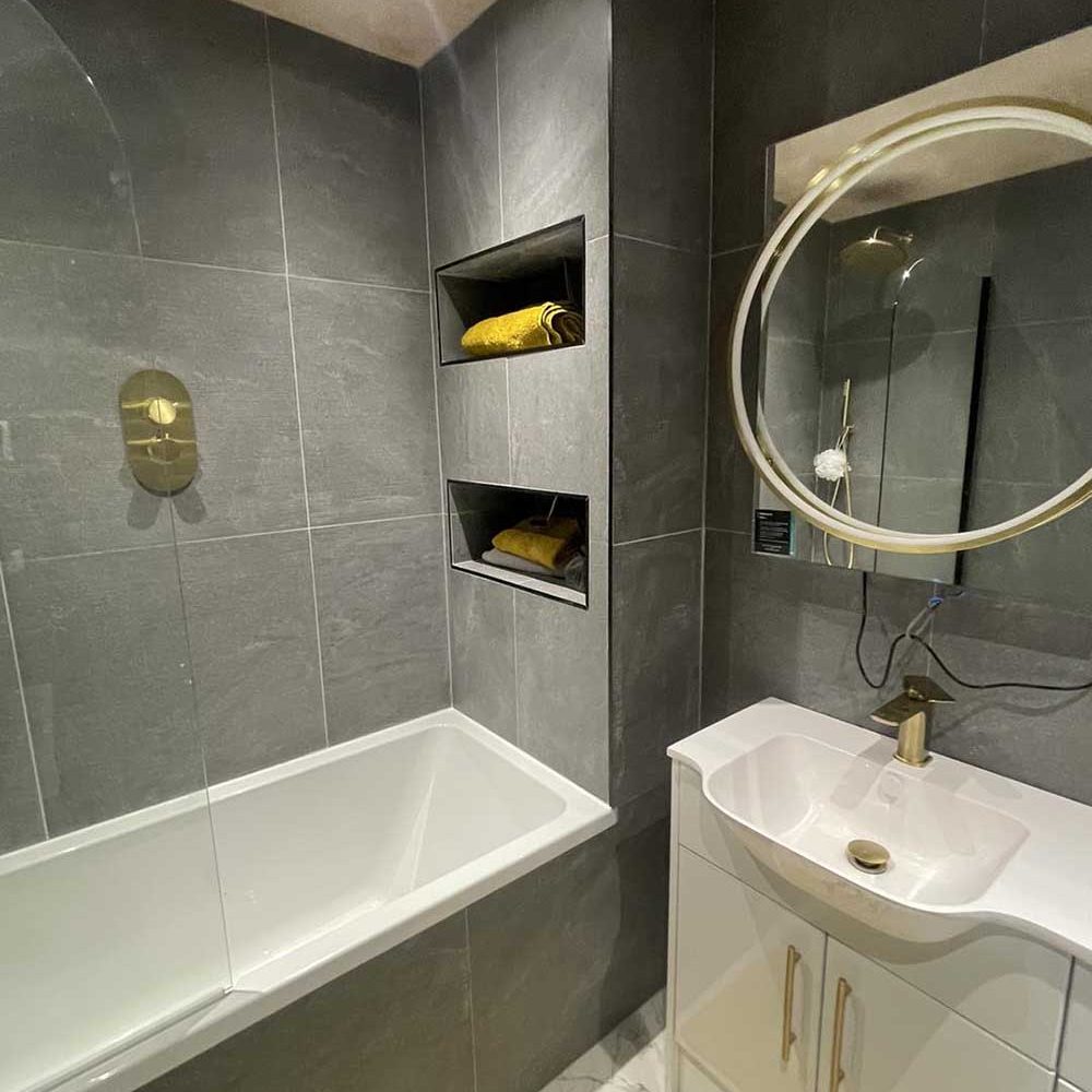 Bathroom with grey marble effect tiles and gold accents